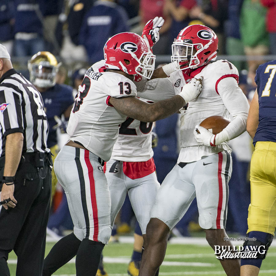 Jonathan Ledbetter (13) and Lorenzo Carter (7) celebrate the fumble recovery that cinched Georgia's victory over Notre Dame