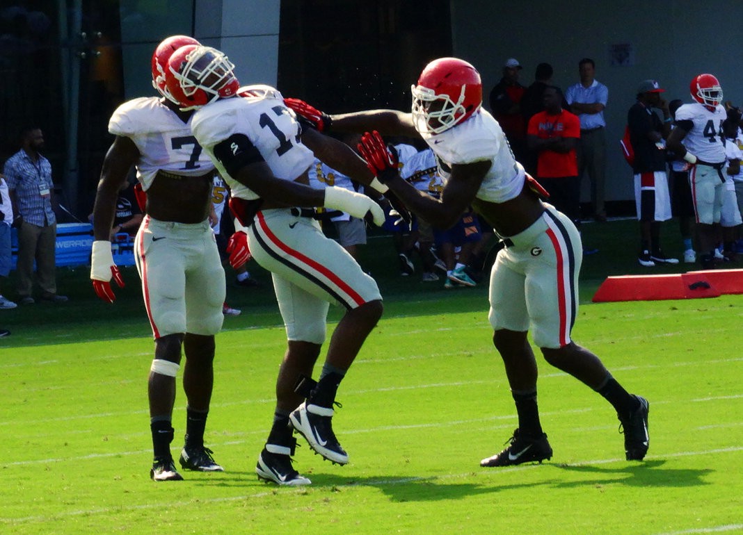 Lorenzo Carter (7) looks on as Davin Bellamy (17) is stood up during a drill