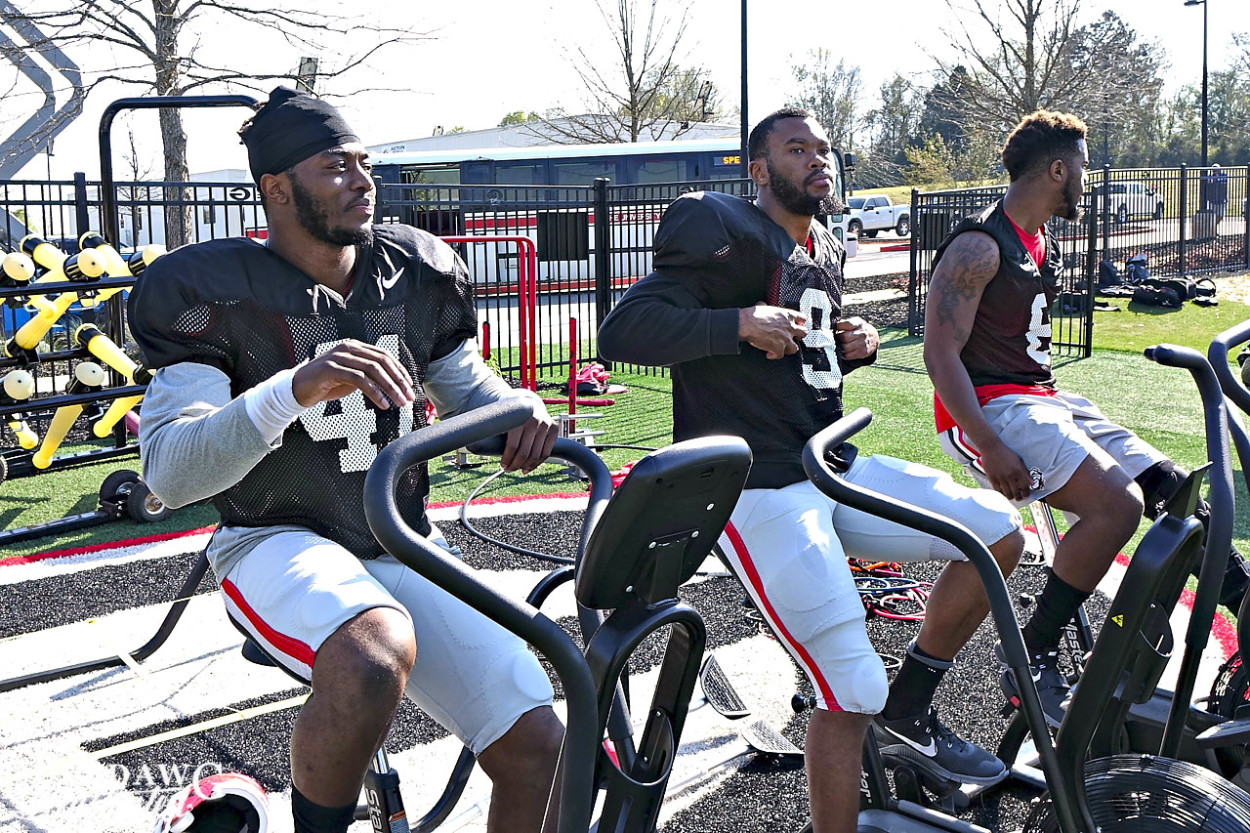 Injured players Chuks Amaechi (41), Reggie Wilkerson (9) and Natrez Patrick (6) work on exercise bikes