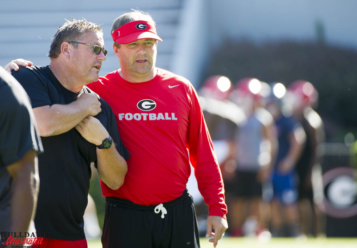 Offensive line coach Sam Pittman and Kirby Smart appear to be discussing it player as they watch a drill