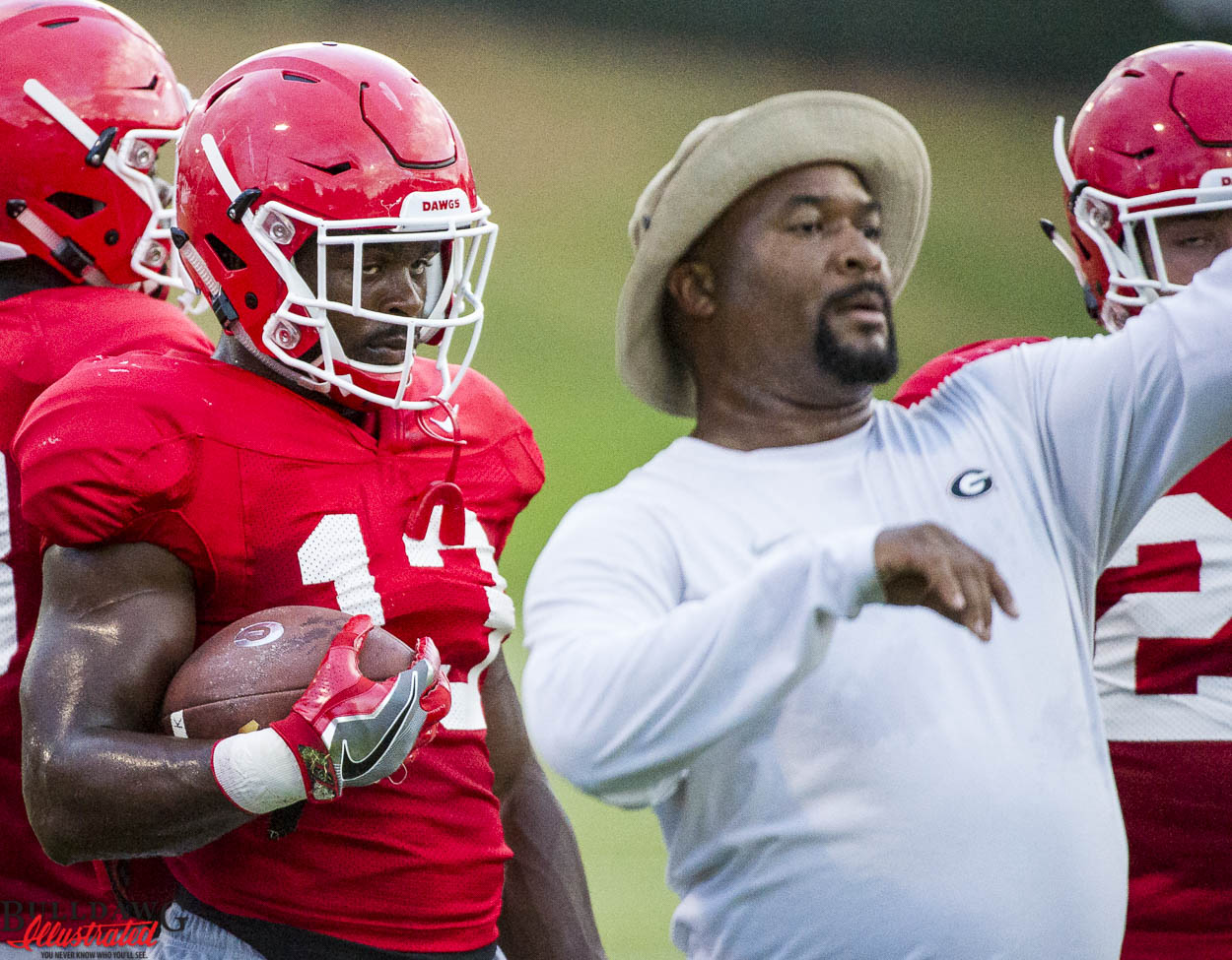 Elijah Holyfield receives instructions from running backs coach Del McGee
