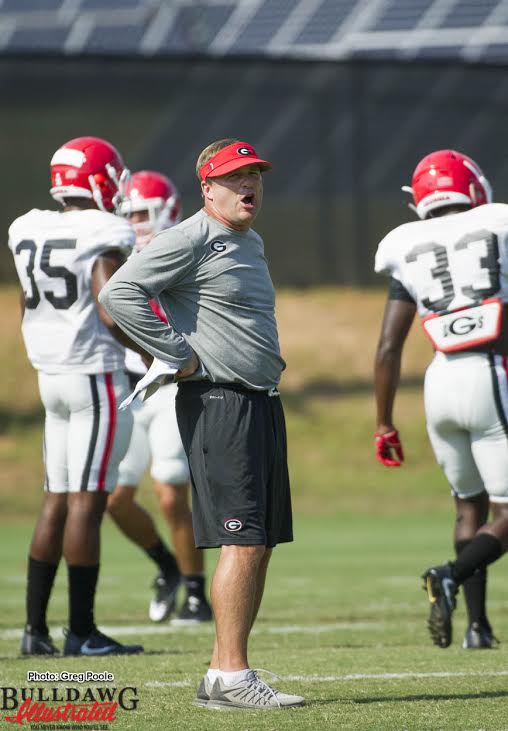 Head Coach Kirby Smart with the defensive backs. In the background is Aaron Davis (35) and Kirby Choates (33)