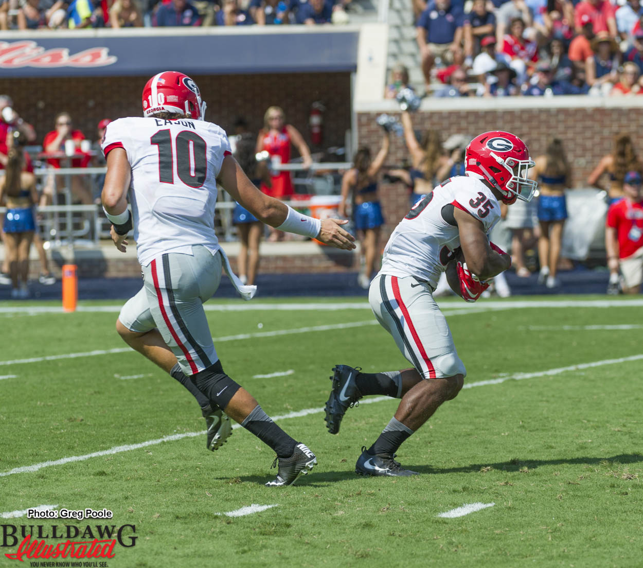 Jacob Eason (10) hands off to Brian Herrien (35)