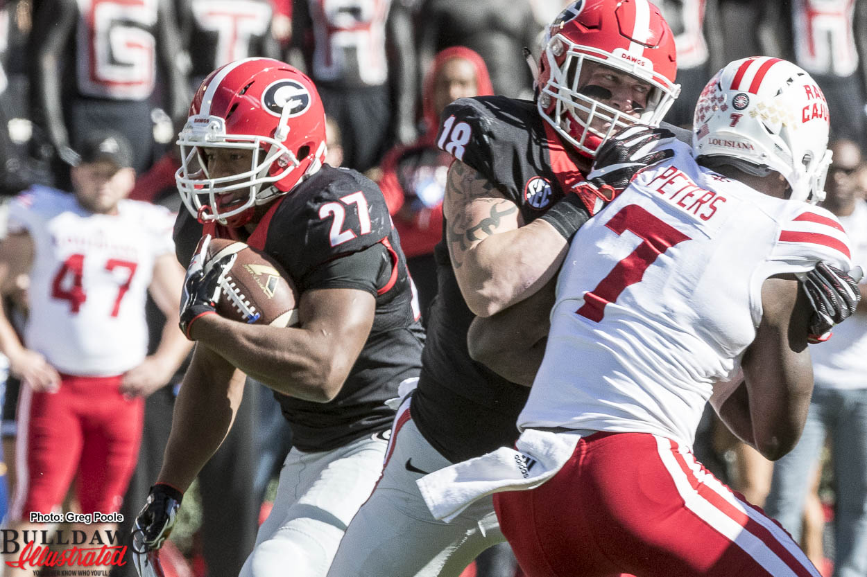 Nick Chubb (27) carrying the ball and Isaac Nauta (18) with the block