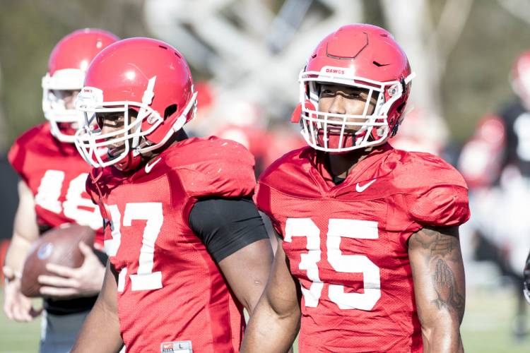 Nick Chubb (27) and Brian Herrien wait to run a drill during practice.