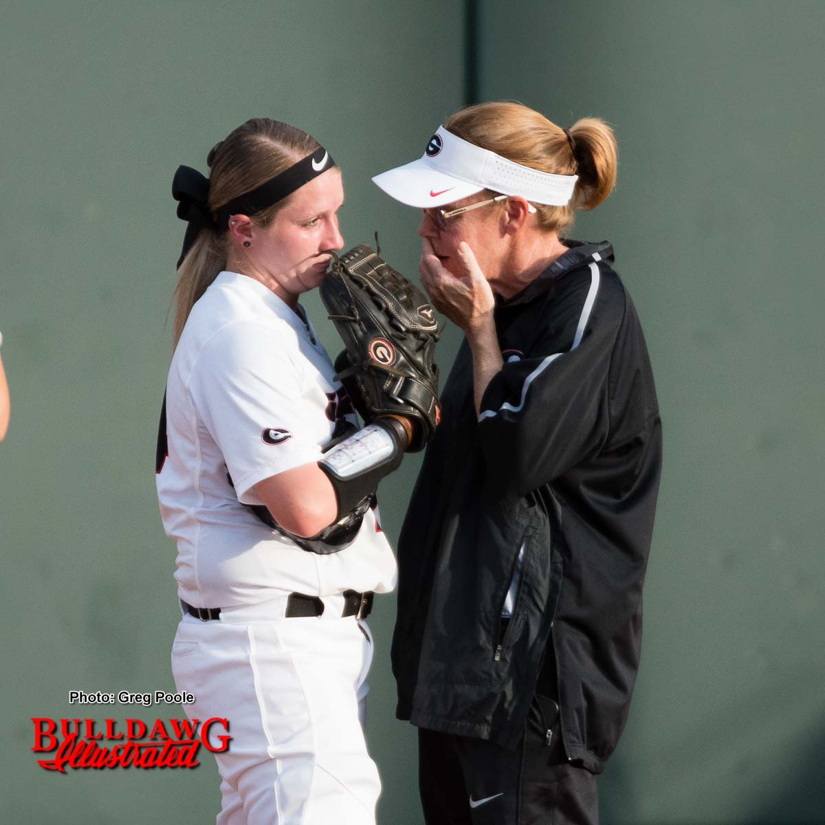 Coach Lu Harris-Champer talks with pitcher Kylie Bass prior to making a change on the mound